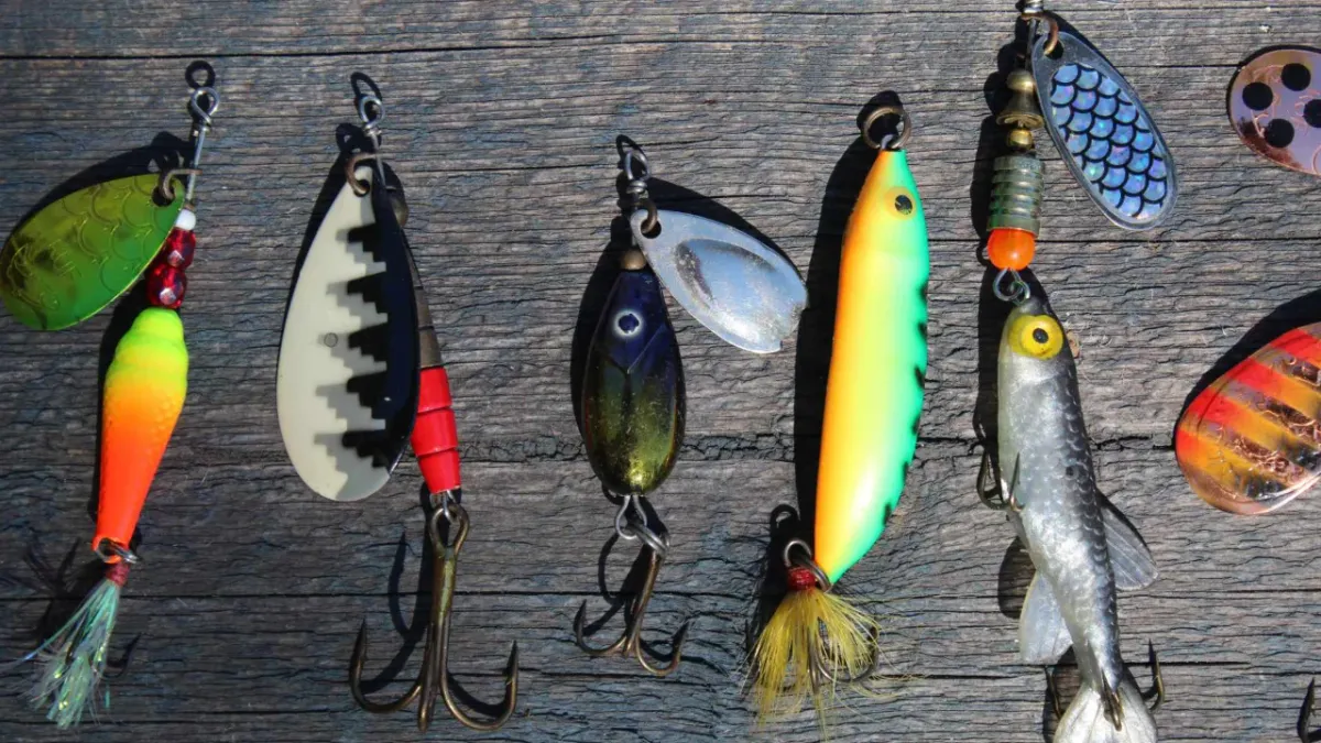 Colorful fishing lures on a wood plank.