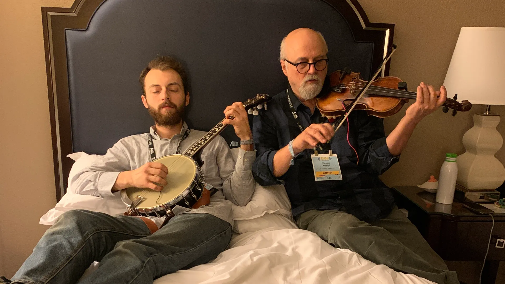 Musicians on a hotel bed with instruments