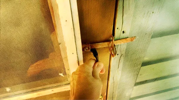 Closeup of a screen door about to be opened