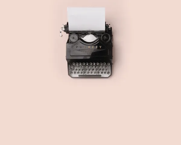 A vintage typewriter on a pink background